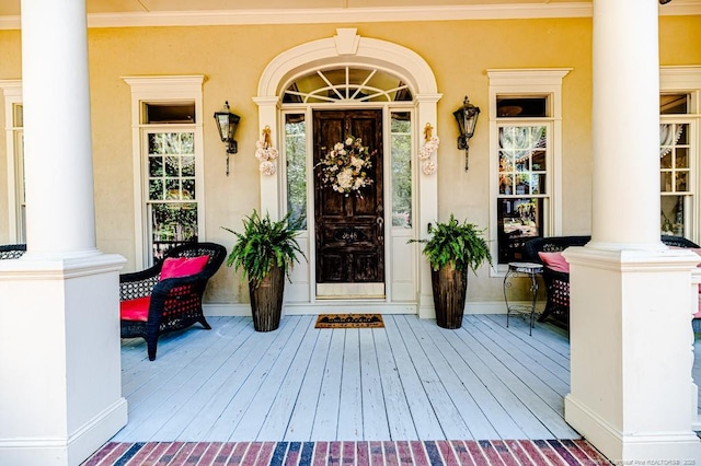 doorway to property with stucco siding and covered porch