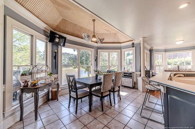 dining area with crown molding, light tile patterned floors, a wealth of natural light, and ornate columns