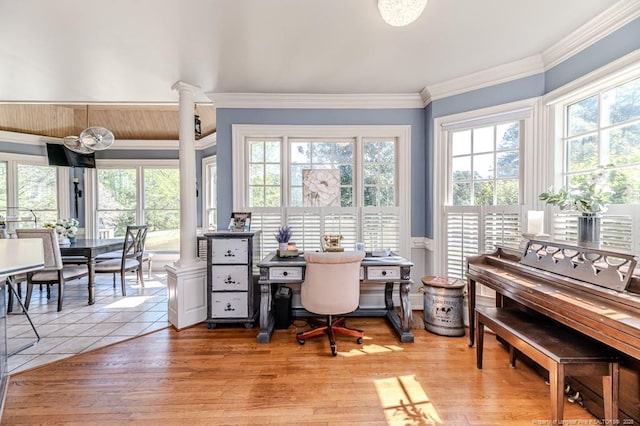 office area with light wood-style floors, ornamental molding, and plenty of natural light