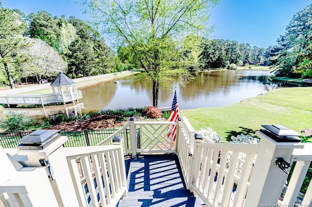 dock area with a water view and a lawn