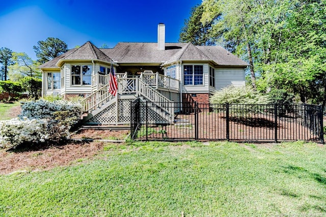 view of front of house with a front yard, a chimney, fence, stairway, and a wooden deck