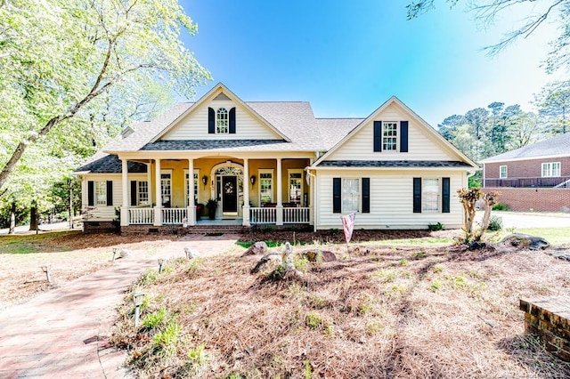 view of front of home with a shingled roof and covered porch