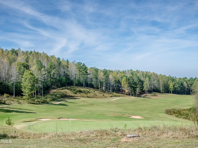 view of community featuring a forest view, golf course view, and a lawn