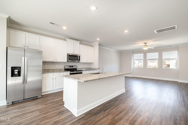 kitchen with white cabinets, appliances with stainless steel finishes, a center island with sink, and sink