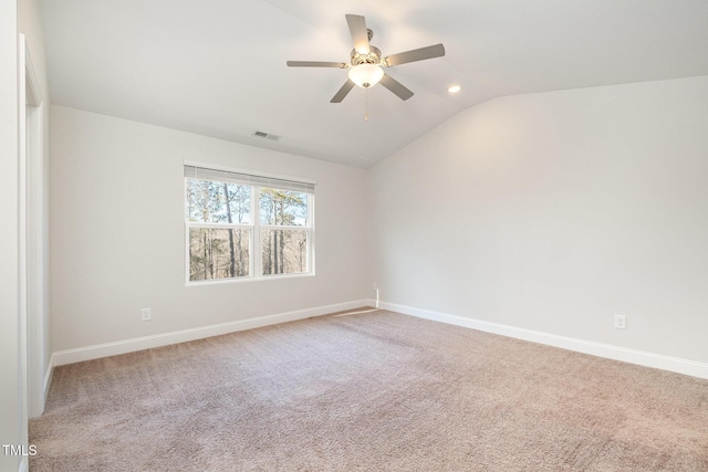 empty room with ceiling fan, light colored carpet, and vaulted ceiling