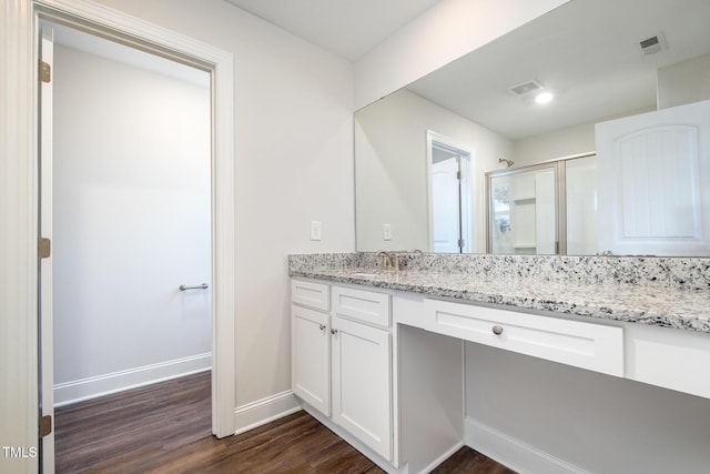 bathroom with walk in shower, vanity, and hardwood / wood-style floors