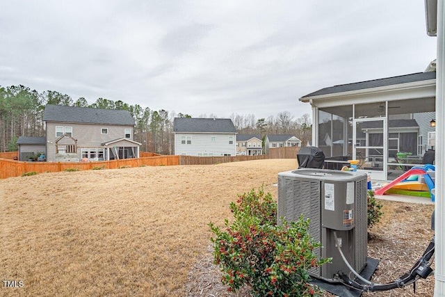 view of yard with central AC unit and a sunroom