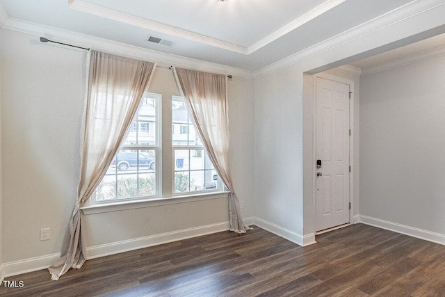 unfurnished room featuring ornamental molding, dark wood-type flooring, and a tray ceiling