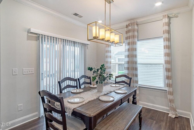 dining room featuring ornamental molding, an inviting chandelier, and dark wood-type flooring