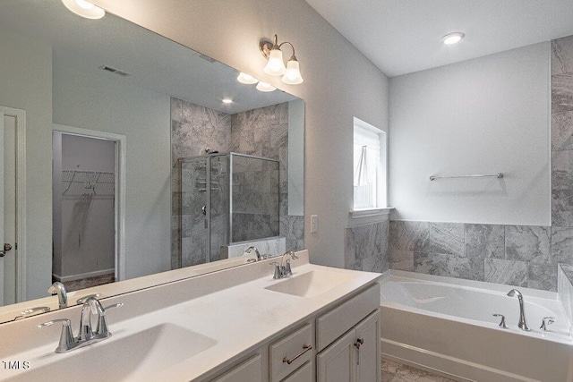 bathroom featuring vanity and independent shower and bath