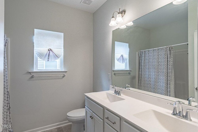 bathroom featuring a shower with shower curtain, vanity, toilet, and tile patterned floors