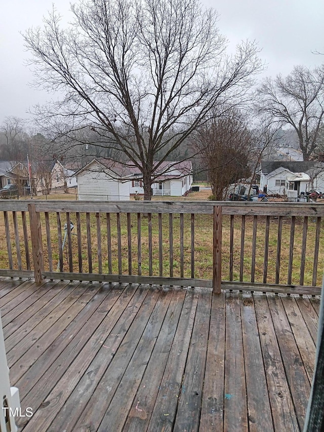 wooden deck featuring a lawn