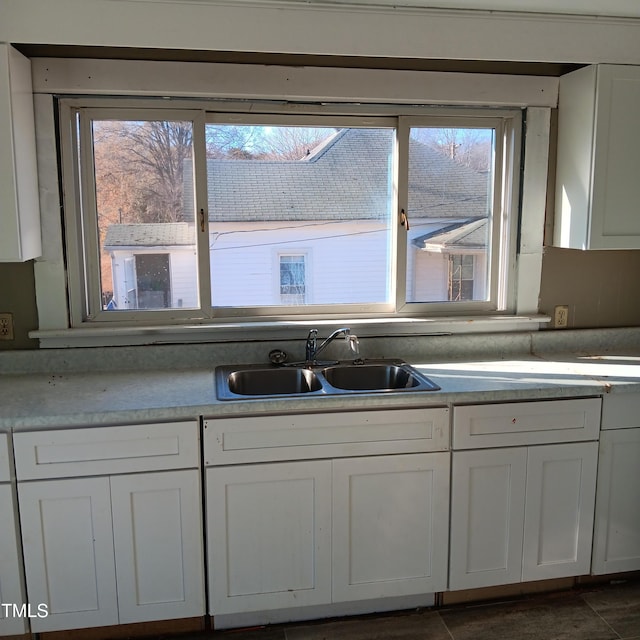 kitchen with a wealth of natural light, white cabinetry, and sink