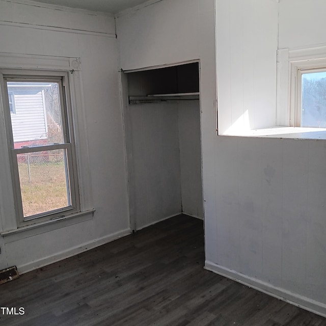 unfurnished bedroom with dark hardwood / wood-style flooring and a closet