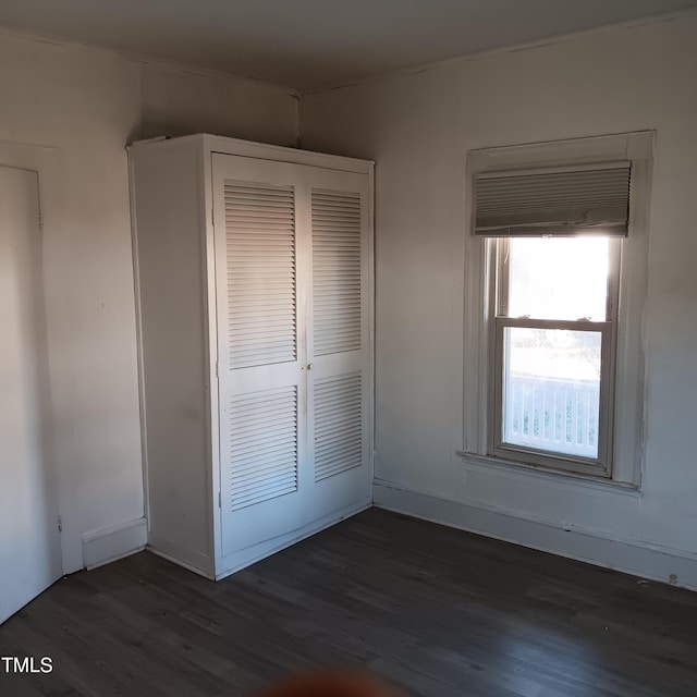 unfurnished bedroom featuring a closet and dark hardwood / wood-style floors