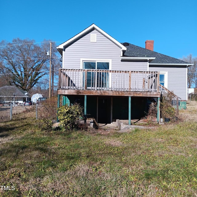 back of property featuring a lawn and a deck