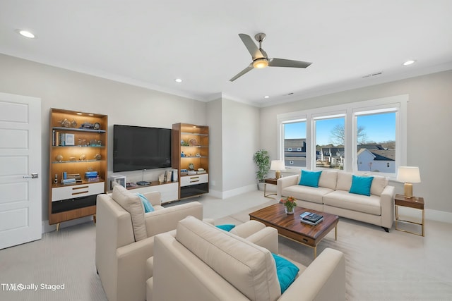 carpeted living room with ceiling fan and ornamental molding