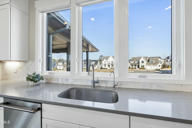 kitchen featuring dishwasher, white cabinetry, plenty of natural light, and sink