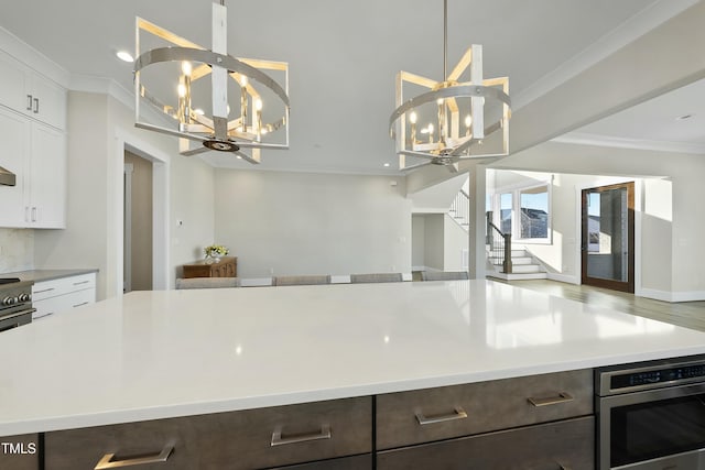 kitchen featuring crown molding, white cabinets, and a chandelier