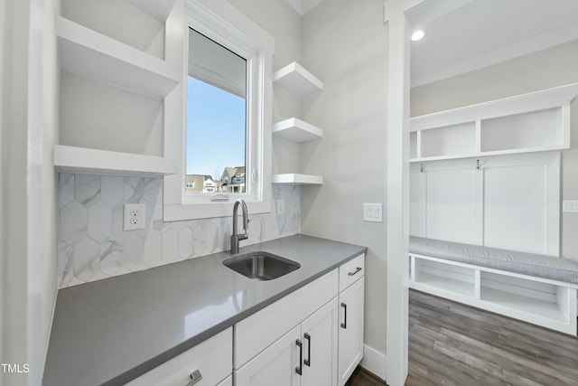 kitchen with backsplash, sink, and white cabinets