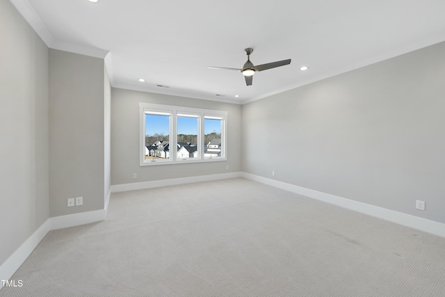 spare room featuring light colored carpet, ceiling fan, and crown molding