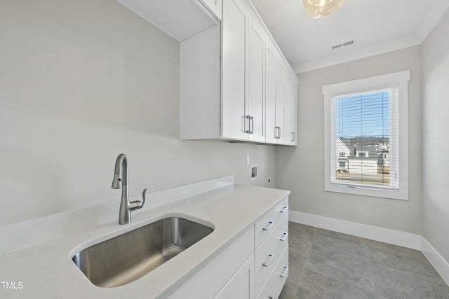 kitchen featuring white cabinetry, sink, and ornamental molding