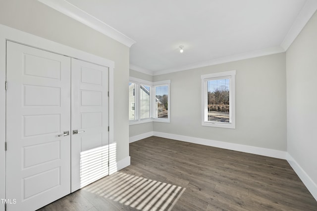 unfurnished bedroom with dark hardwood / wood-style flooring, a closet, and ornamental molding