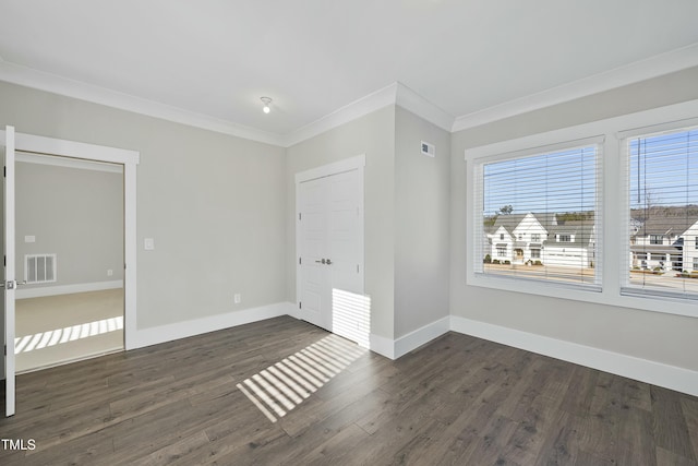 unfurnished bedroom with ornamental molding and dark wood-type flooring