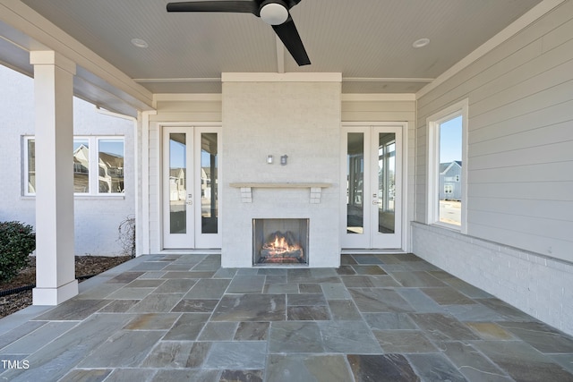 view of patio with french doors, an outdoor brick fireplace, and ceiling fan