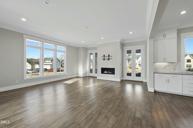 unfurnished living room with french doors, plenty of natural light, and crown molding