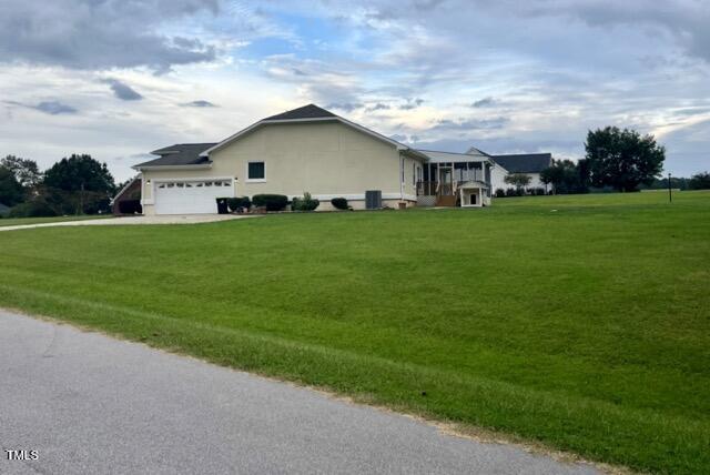 view of side of property with a yard and a garage