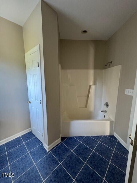 bathroom featuring tile patterned flooring and shower / bathing tub combination