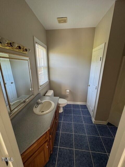 bathroom featuring tile patterned floors, vanity, and toilet