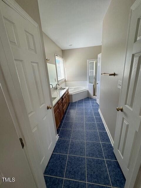 bathroom with tile patterned flooring, vanity, and a bathing tub