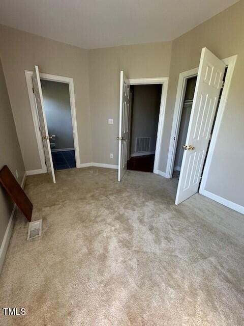 unfurnished bedroom featuring light colored carpet and a closet