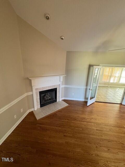 unfurnished living room with a tile fireplace and hardwood / wood-style flooring