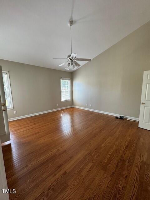 empty room with a wealth of natural light, ceiling fan, and dark hardwood / wood-style floors