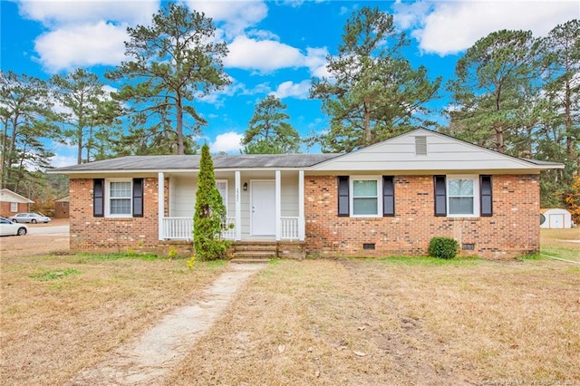 ranch-style home featuring covered porch and a front yard