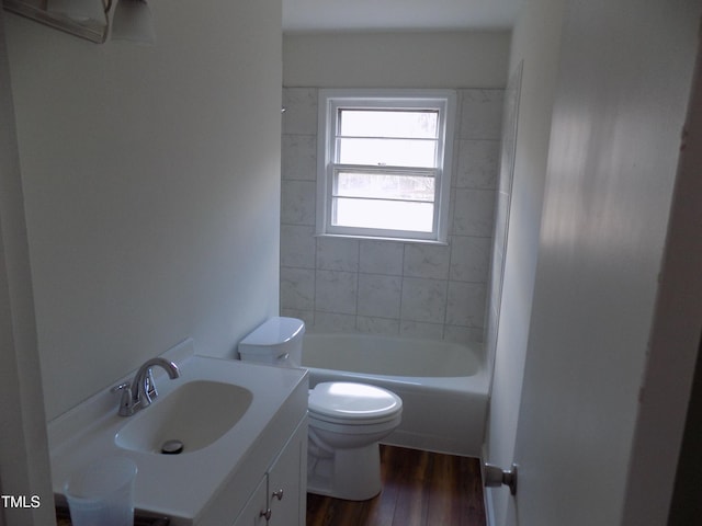 full bathroom featuring hardwood / wood-style flooring, vanity, toilet, and tiled shower / bath