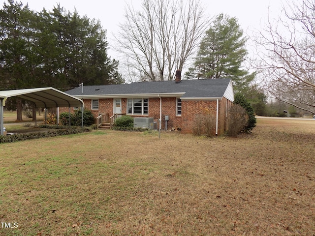 view of front of property featuring a front yard, a carport, and central air condition unit