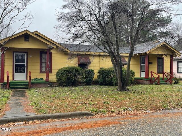 view of front of property with covered porch and a front yard