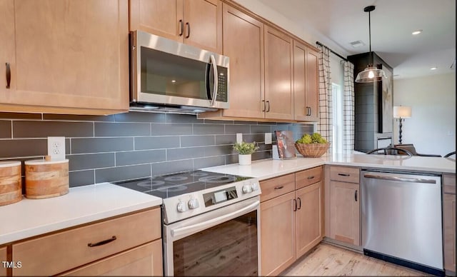 kitchen with hanging light fixtures, light brown cabinets, backsplash, and appliances with stainless steel finishes