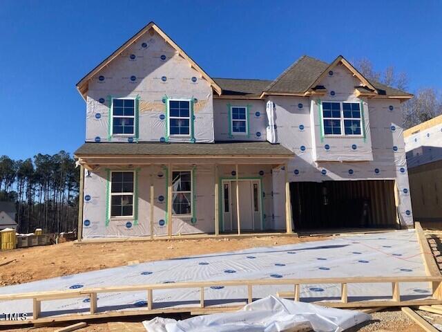 unfinished property with covered porch and a garage