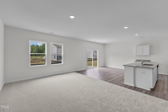 unfurnished living room with dark hardwood / wood-style flooring and sink