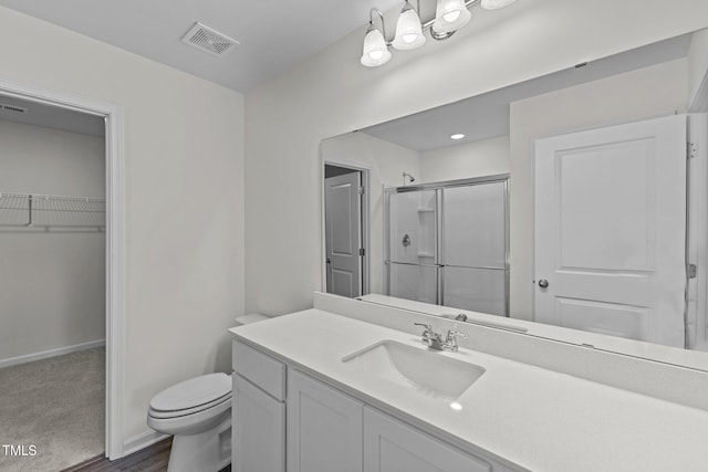 bathroom featuring hardwood / wood-style floors, vanity, toilet, and walk in shower