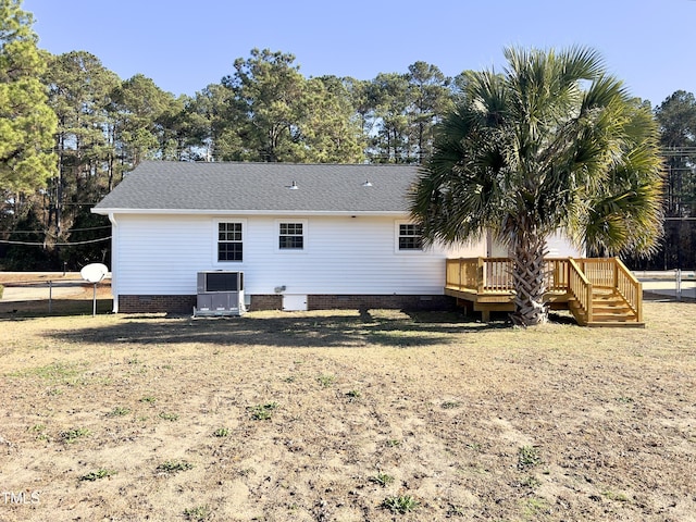 rear view of house featuring a deck, a yard, and central air condition unit