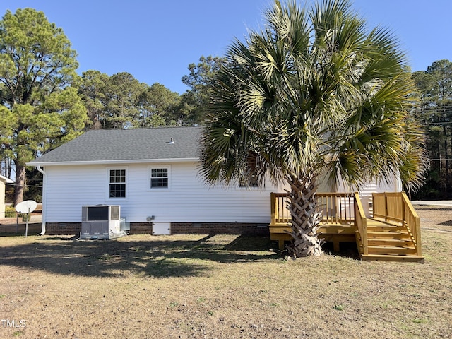 rear view of property with central AC, a yard, and a deck