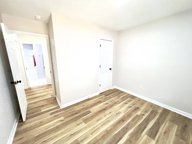 unfurnished bedroom featuring light wood-type flooring and a closet