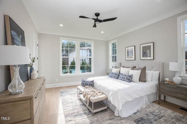 bedroom with ceiling fan, ornamental molding, and light hardwood / wood-style flooring