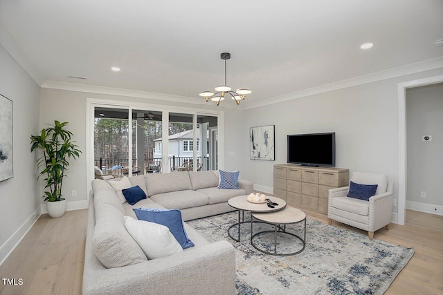 living room featuring crown molding, a chandelier, and light hardwood / wood-style flooring